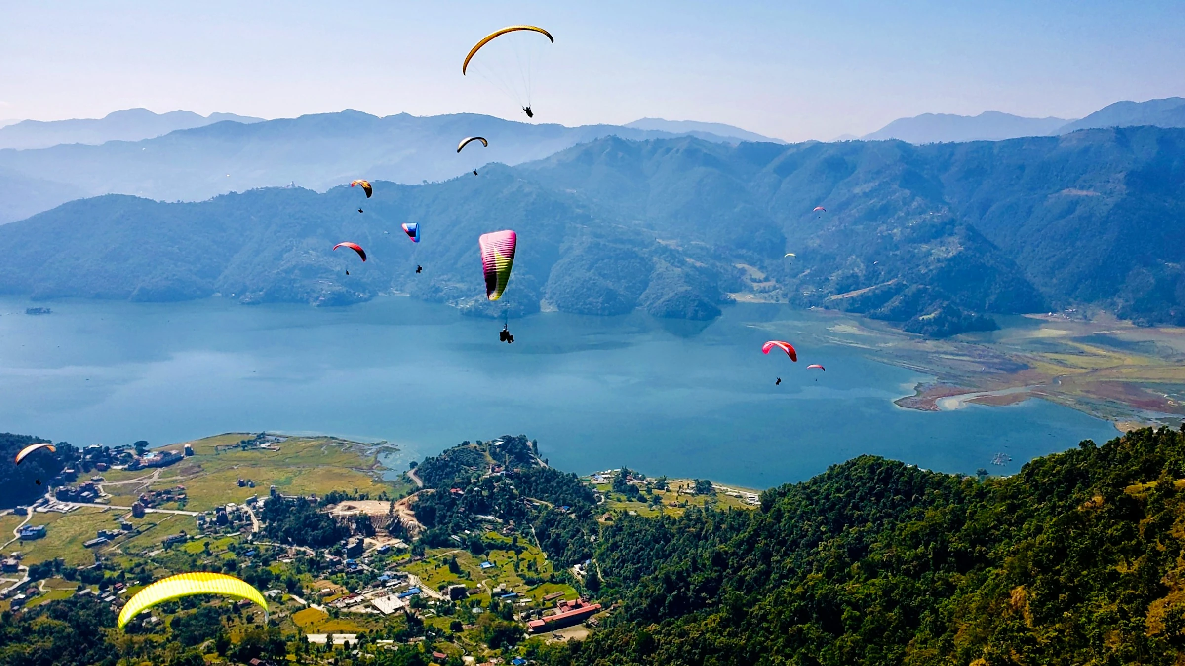 Gleitschirmflieger über Berglandschaft bei klarem Wetter